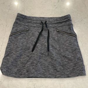 Athleta charcoal skort with side zip pockets, back pockets and tie waist.